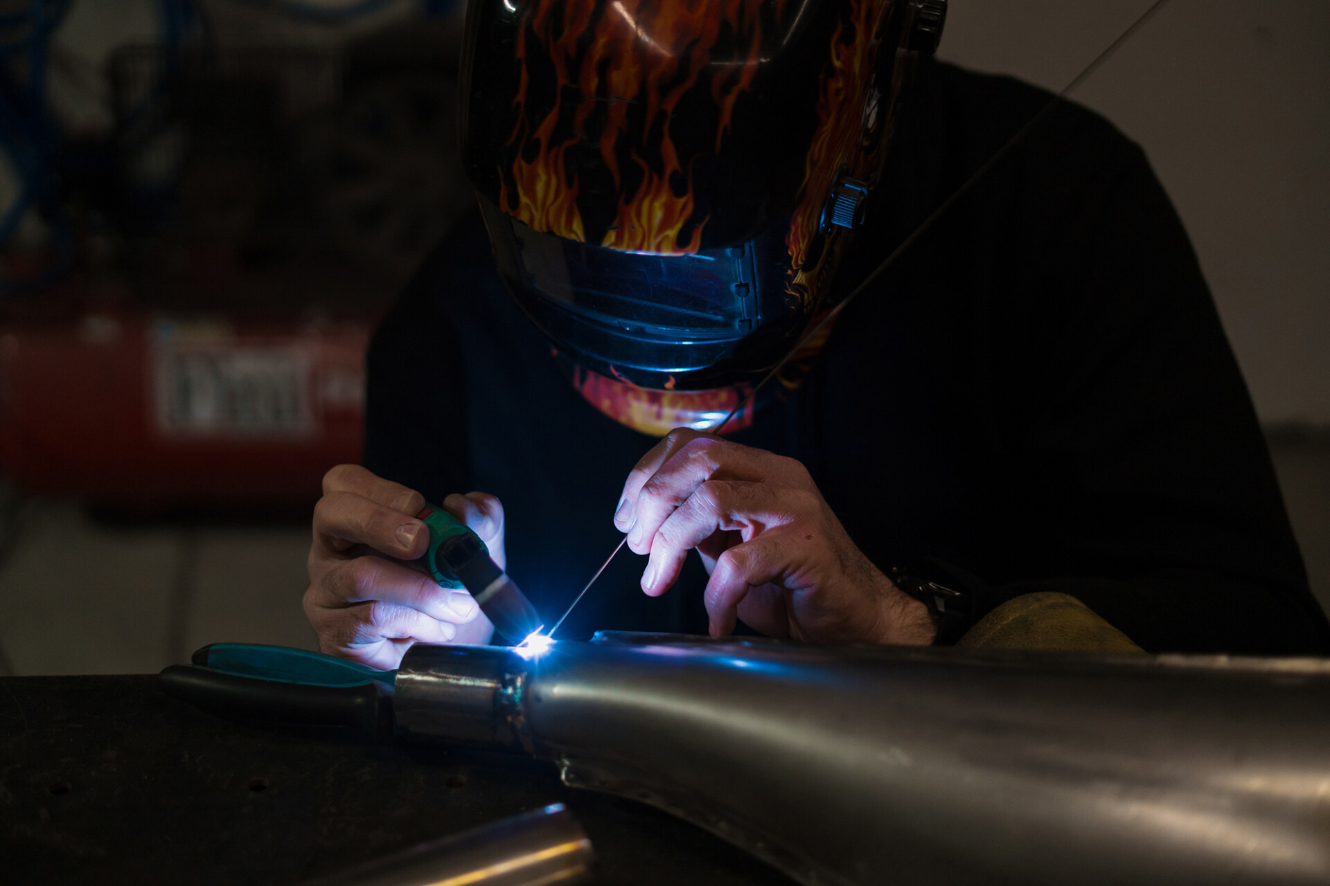 Man working with argon welding machine garage